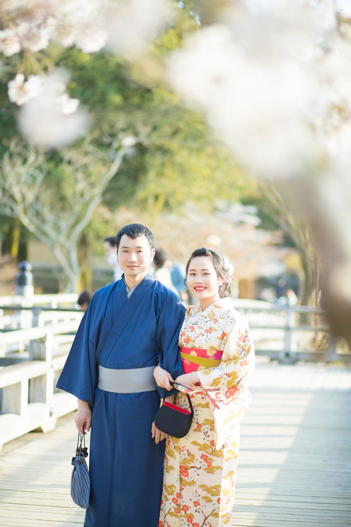A happy couple in kimonos under cherry blossoms, embodying cultural elegance.